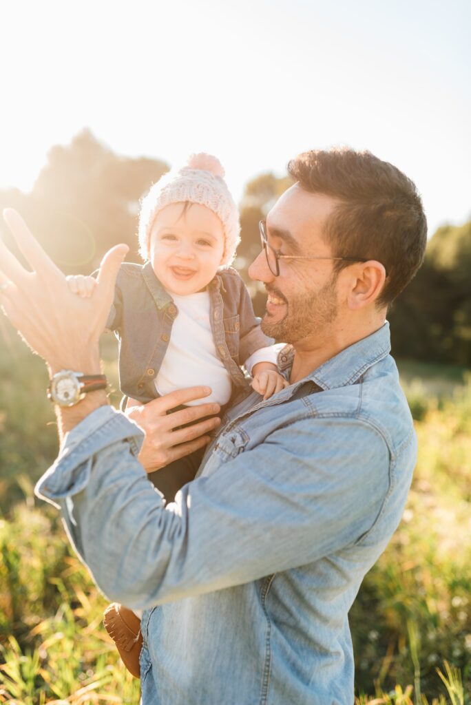 A father playing with his child in the sun.