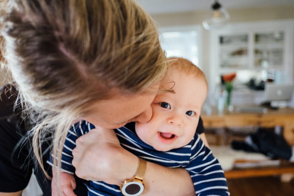 A mother kissing her baby in family photo poses