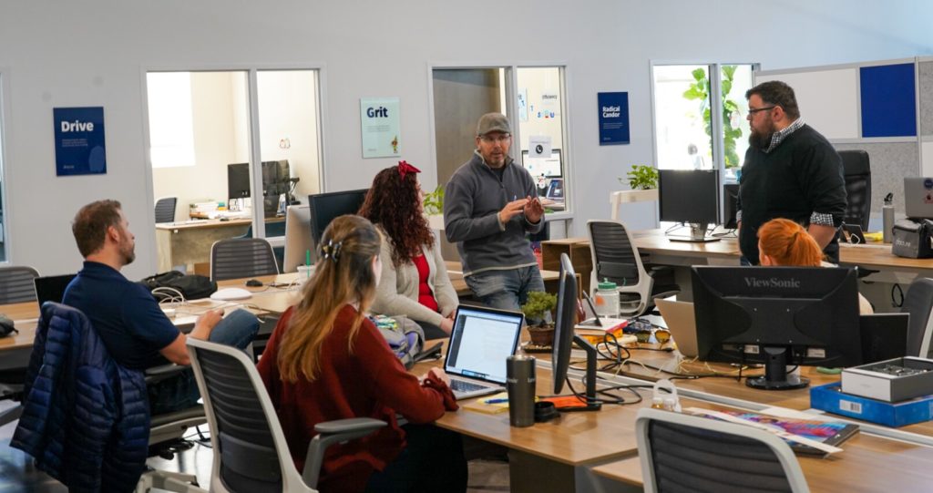 Fracture team members engaged in a collaborative discussion in a modern office space