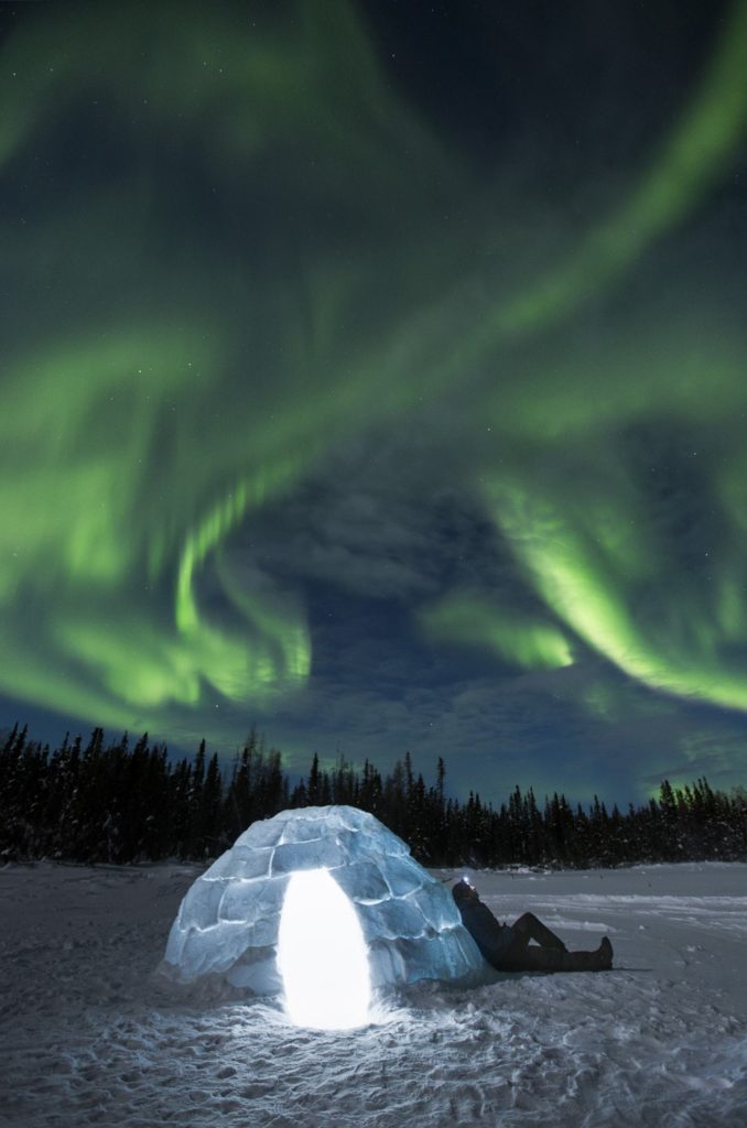 The northern lights over an igloo.