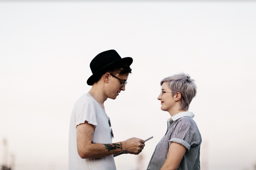 Couple exchanging loving glances during their engagement photo shoot, with the man holding a letter