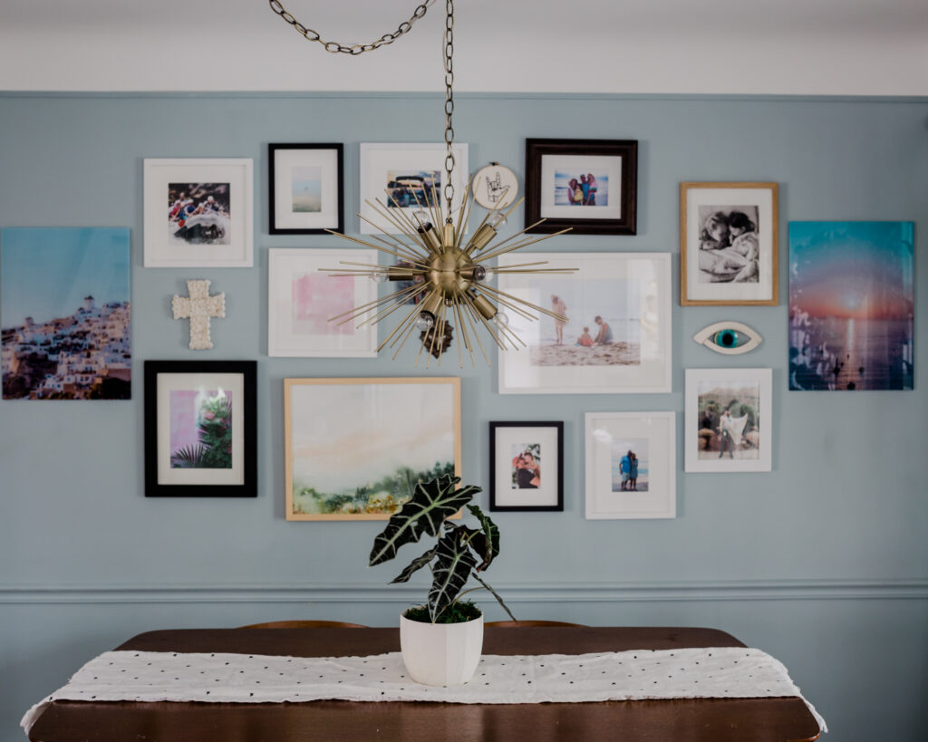 A mixed media gallery wall in a dining room.