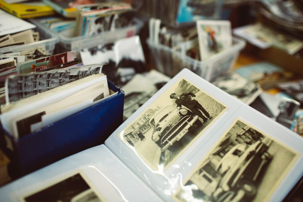 Hands holding a stack of old printed photographs, revealing nostalgic memories