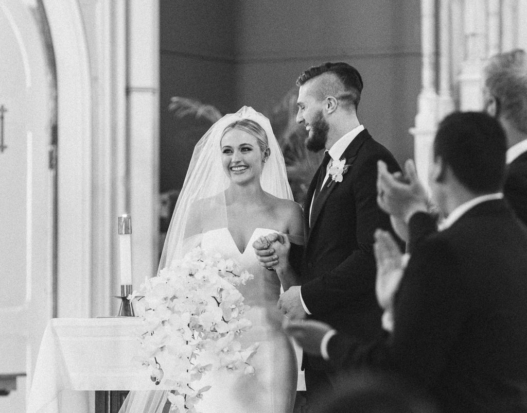 Bride and groom smiling joyfully at the altar, capturing a perfect wedding ceremony moment