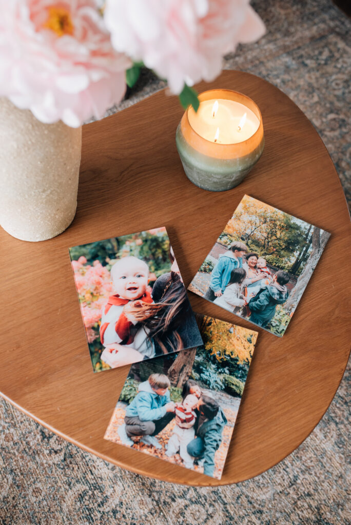 A set of small Mother's Day glass prints laid out on a table, featuring a mom holding her kid, a candid family photo, and grandma with all the grandkids.
