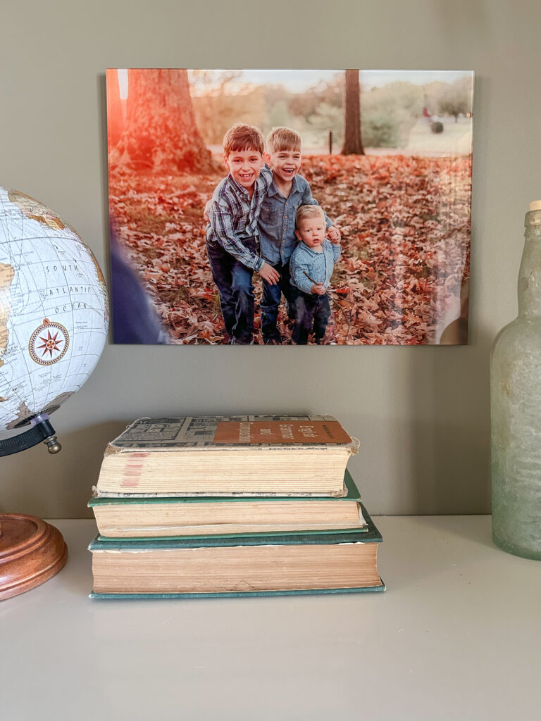 Photo of kids among fall leaves, printed on glass, mounted above a cute bookshelf