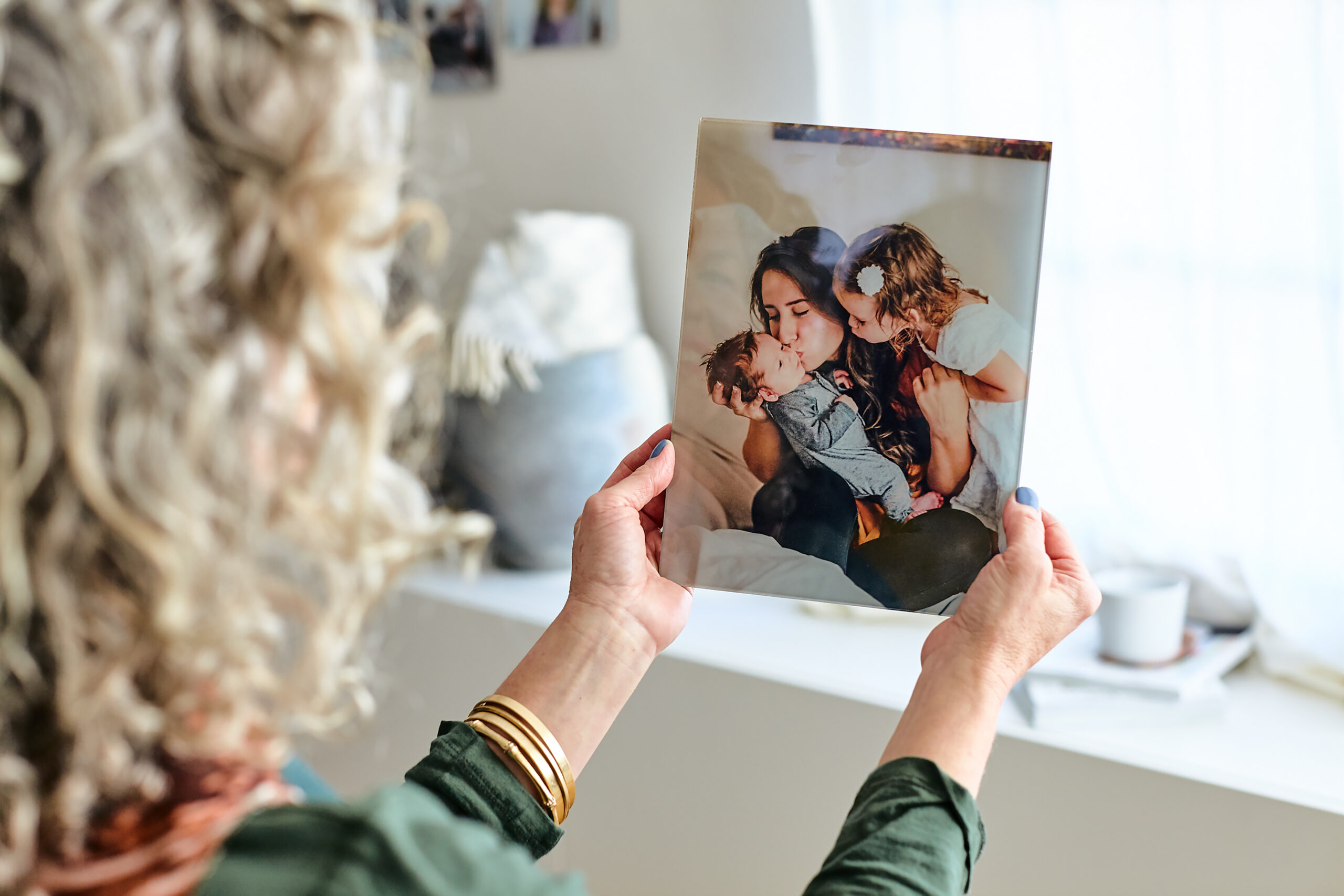 Grandma holding a glass print of her daughter with the grandkids, one of the best Mother's Day gifts for grandma.