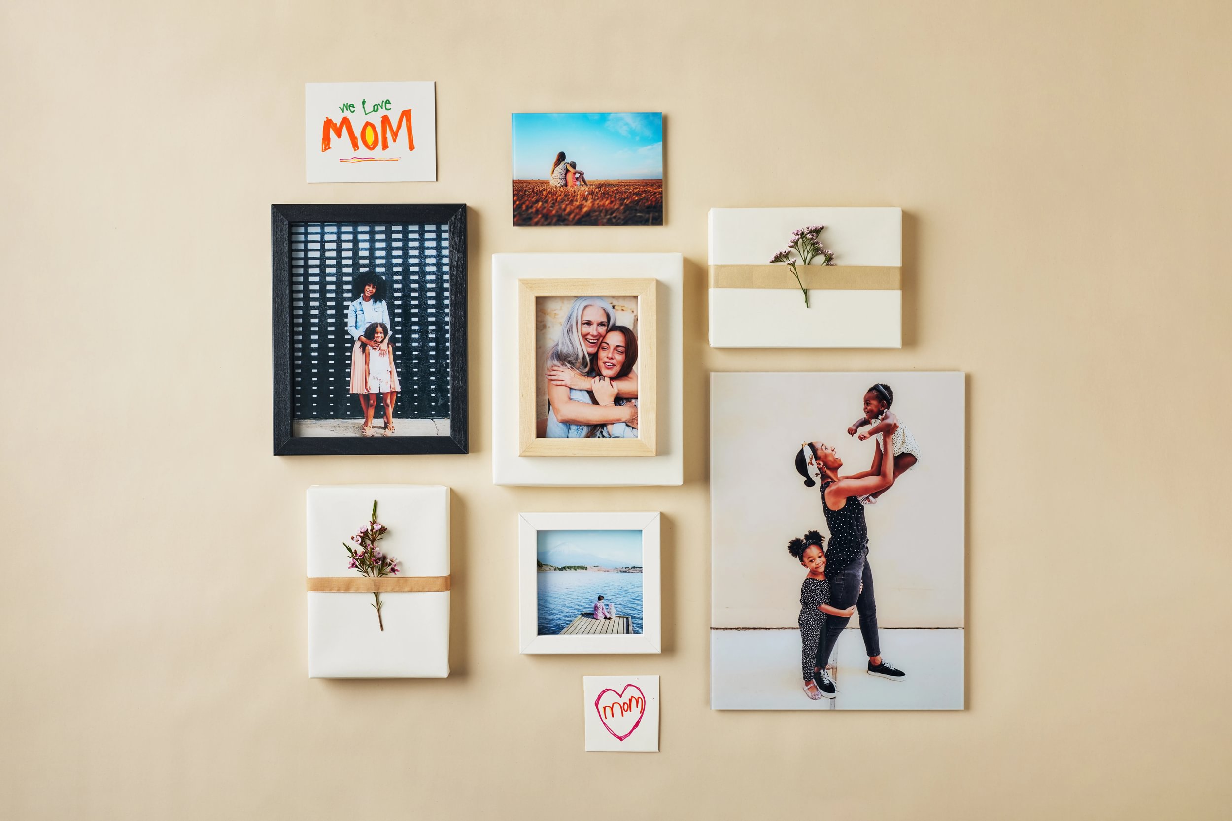 Mother's Day wall decor: a mix of glass prints laid out with gift boxes and cards as a Mother's Day gift