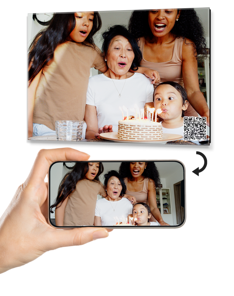 A demonstration of a StoryGlass glass print from Fracture. An arrow points from the QR code on the print to the full screen video of the moment playing back on the screen.