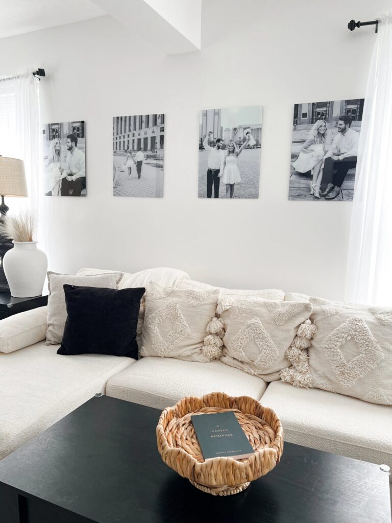 A beautiful black and white series of wedding photos printed on glass are mounted above a sofa, the focal point of the room.